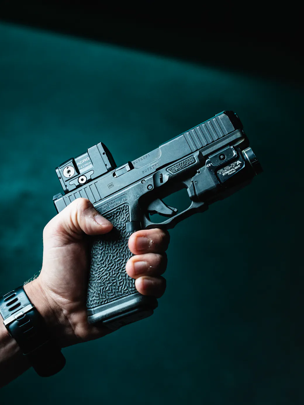 Handgun with a red dot optic mounted, slide profile view
