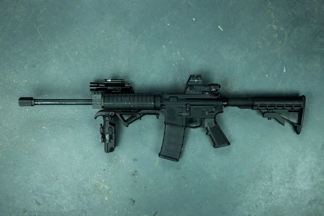 Rifle missing sling, backup irons, and spare magazines